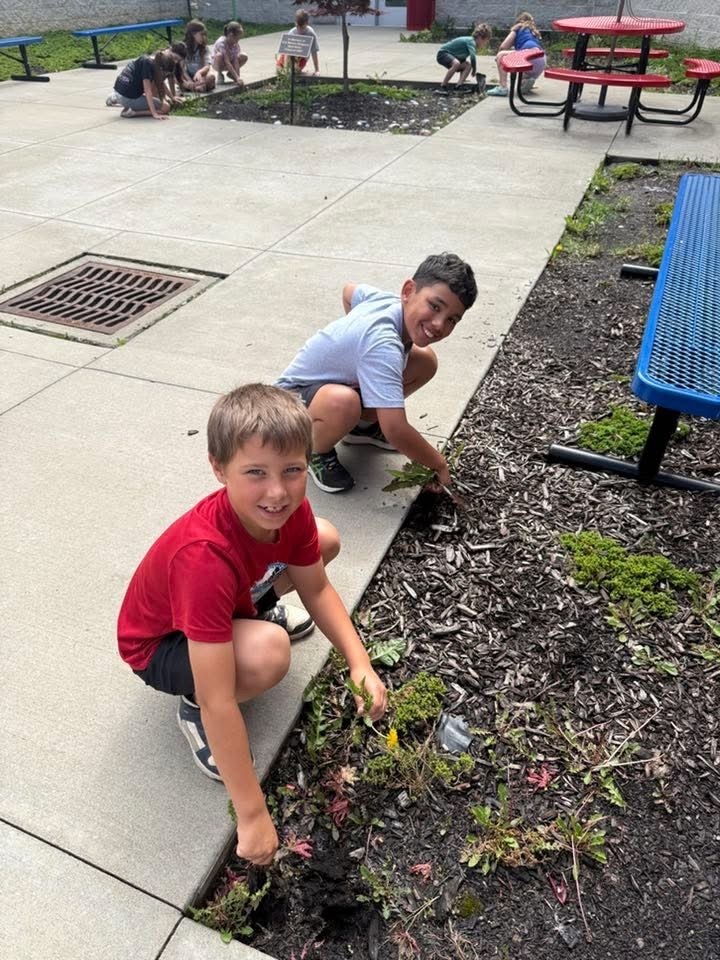 Students weeding a flower bed.
