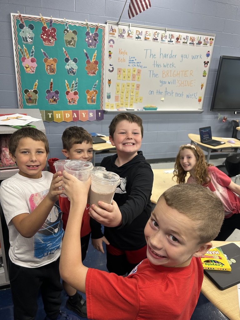 Children holding a drink with a ghost on it