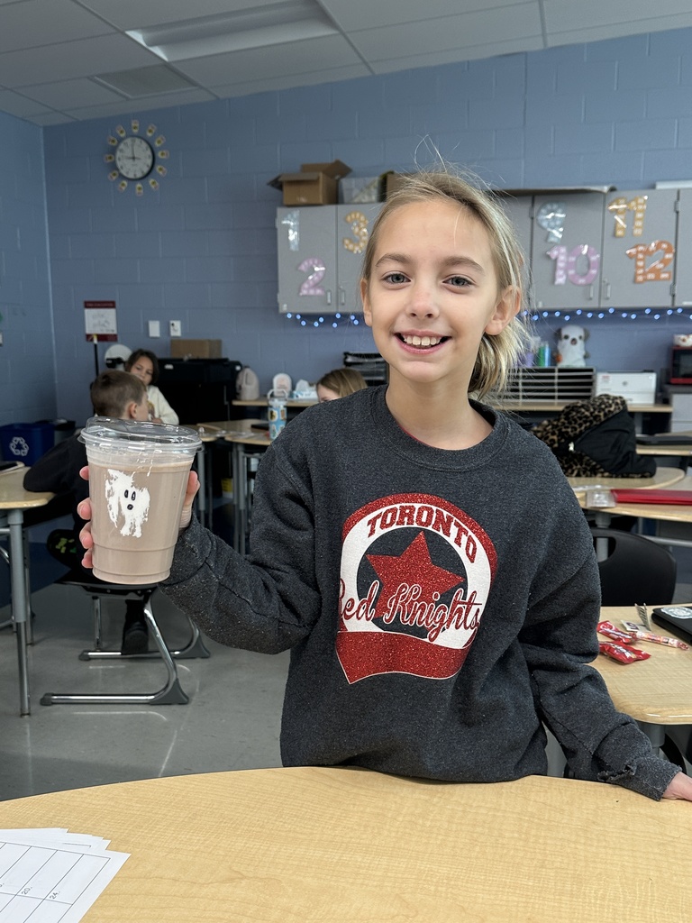 Child holding a drink with a ghost on it