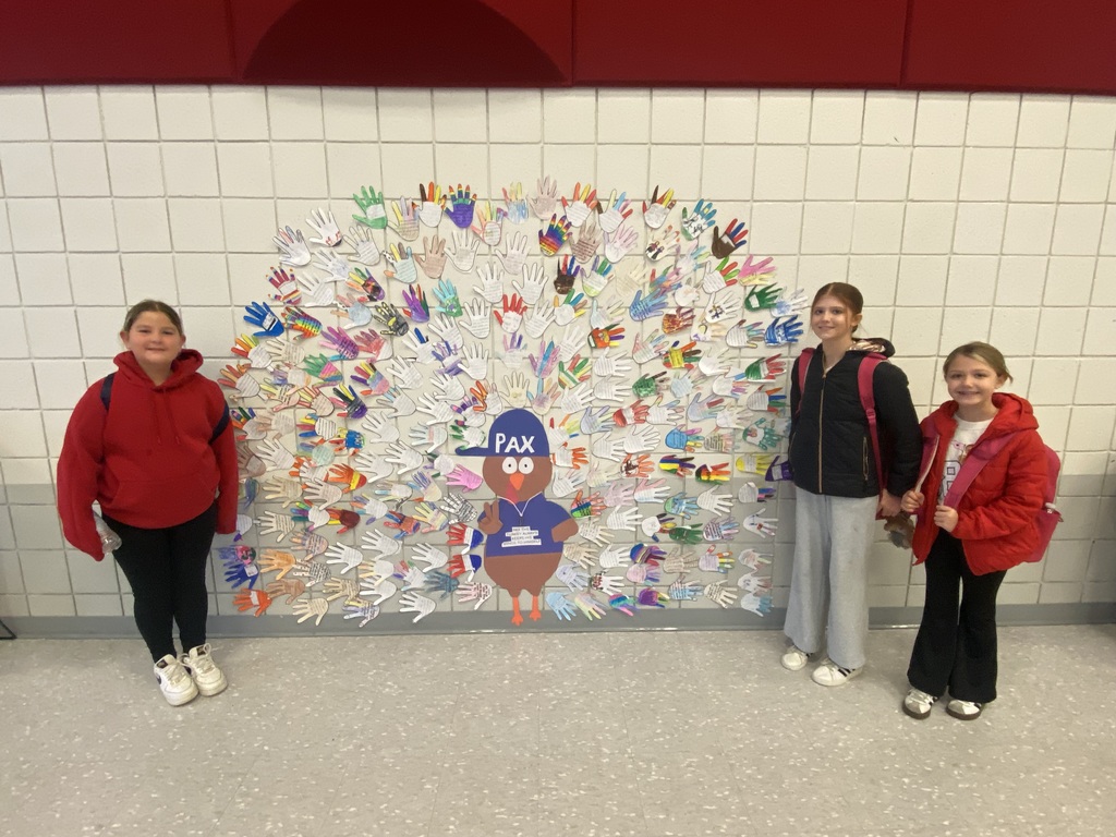 kids standing next to a turkey with decorated hands around it as feathers