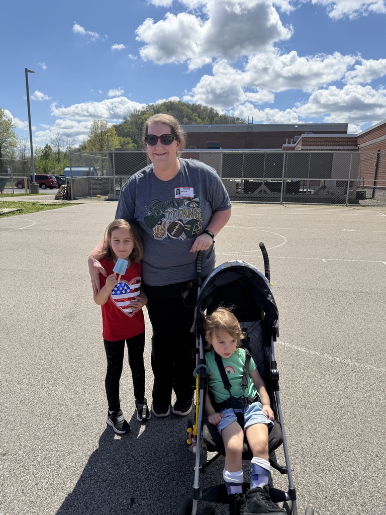 Student and mom with sister and pospsicle on playground.