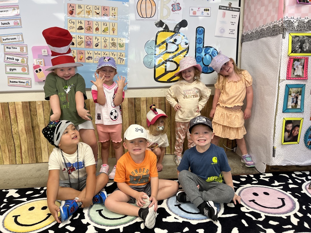 Toronto preschool students celebrate Attendance Spirit Week by participating in Hat Day. Students are pictured smiling and posing together in their classroom and school hallway while wearing a variety of colorful and creative hats, including baseball caps, bucket hats, character hats, and other fun styles.