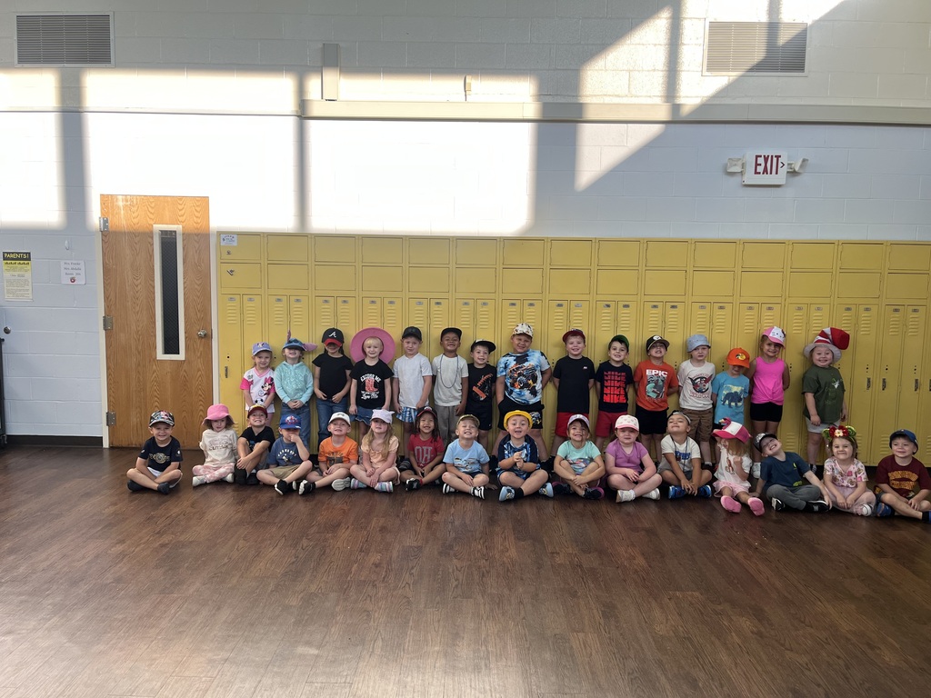 Toronto preschool students celebrate Attendance Spirit Week by participating in Hat Day. Students are pictured smiling and posing together in their classroom and school hallway while wearing a variety of colorful and creative hats, including baseball caps, bucket hats, character hats, and other fun styles.