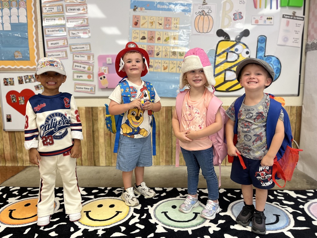 Toronto preschool students celebrate Attendance Spirit Week by participating in Hat Day. Students are pictured smiling and posing together in their classroom and school hallway while wearing a variety of colorful and creative hats, including baseball caps, bucket hats, character hats, and other fun styles.
