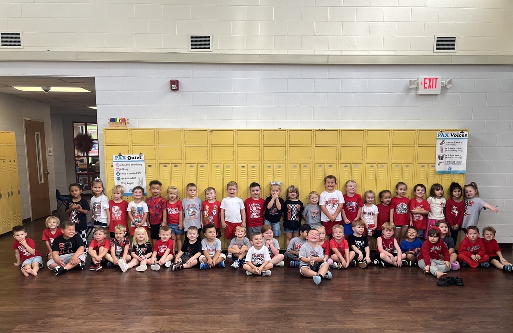 A large group of Toronto preschool students poses together in a school hallway in front of yellow lockers. The students are wearing red, white, and black clothing, including Toronto and Red Knights shirts, to celebrate the final day of Attendance Spirit Week by showing their school colors and Red Knight pride.