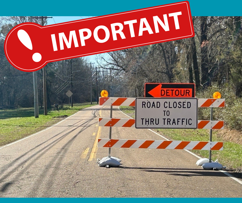 Photo of a two-lane road with an orange and white barricade across it saying "road closed to thru traffic.  detour".  On the top is a red box with an exclamation point and word Important in white.