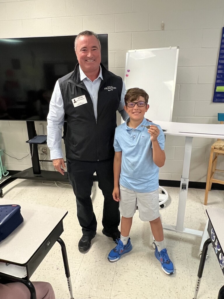 Mayor Wissman beside a student in blue shirt who is holding a key to the city