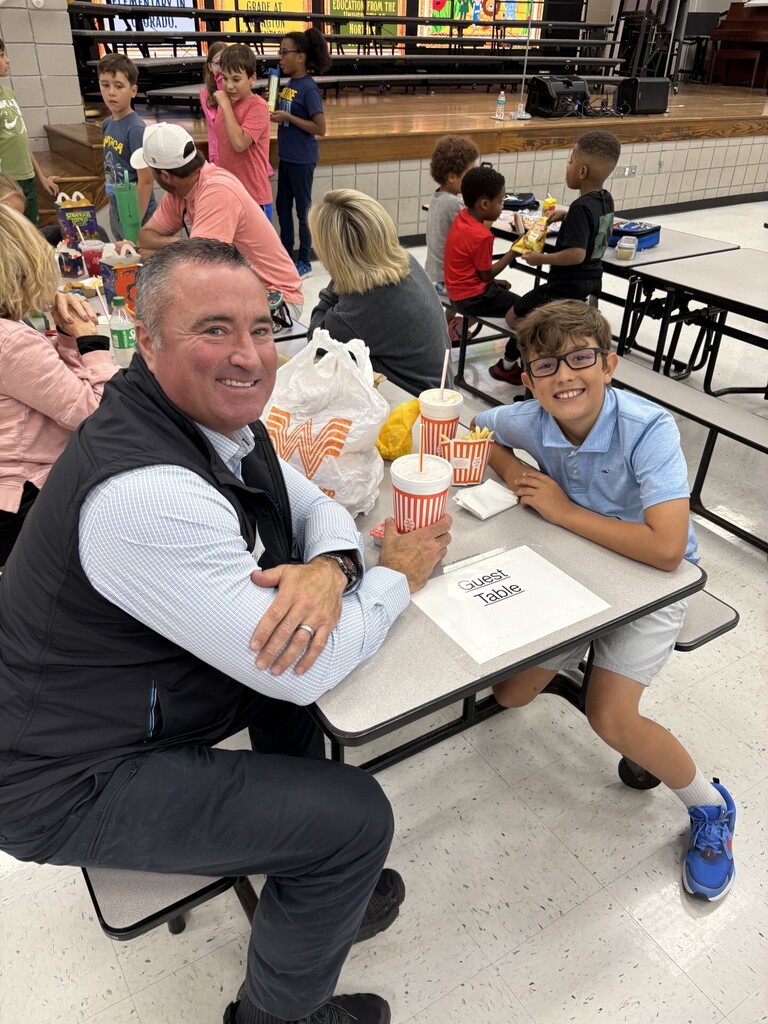 Mayor Wissman and student at school cafeteria table posing for picture