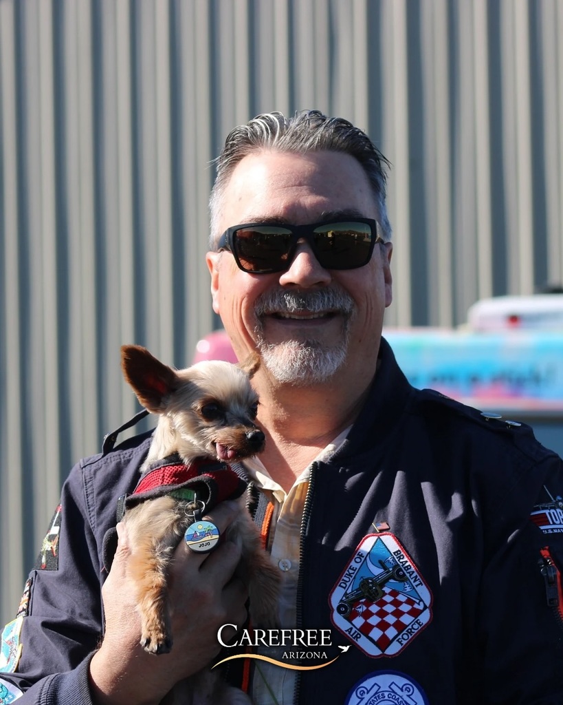 Man holding small dog with tongue out