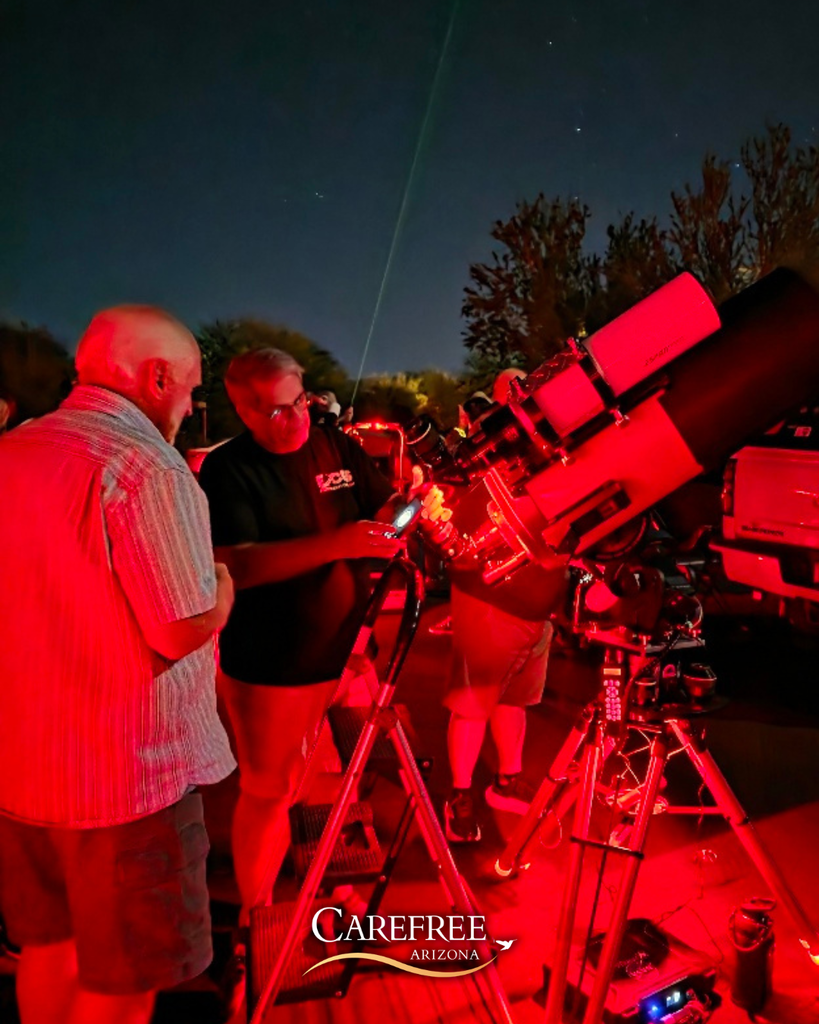Participant looking at telescope with astronomer