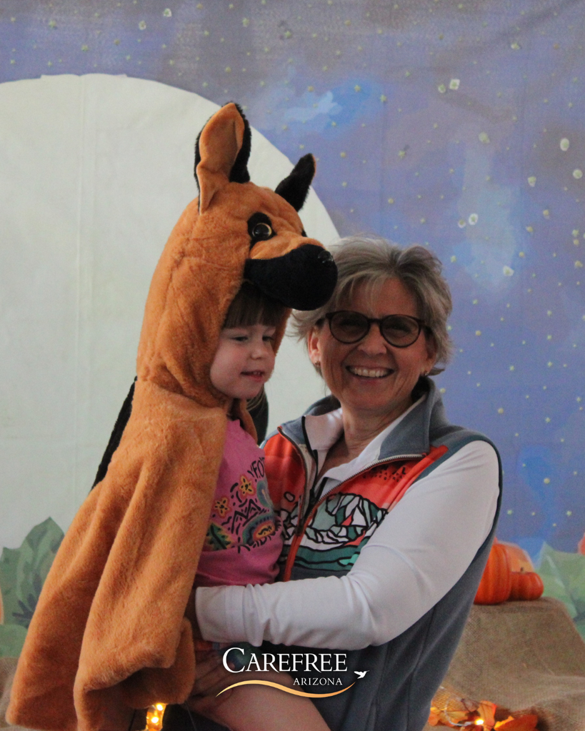 Little girl in dog costume and woman smiling