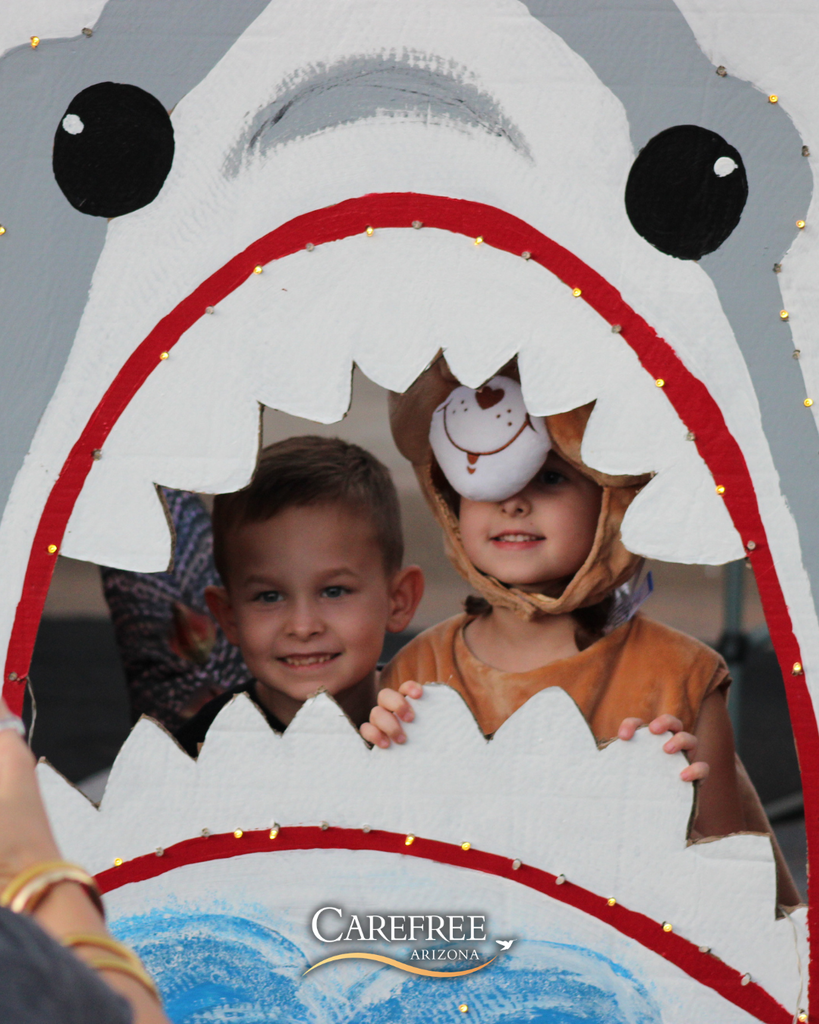 Boys smiling in costume in a shark cutout