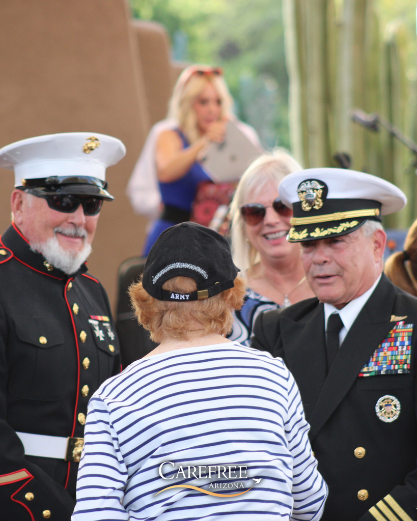 Two dressed military men talking to woman