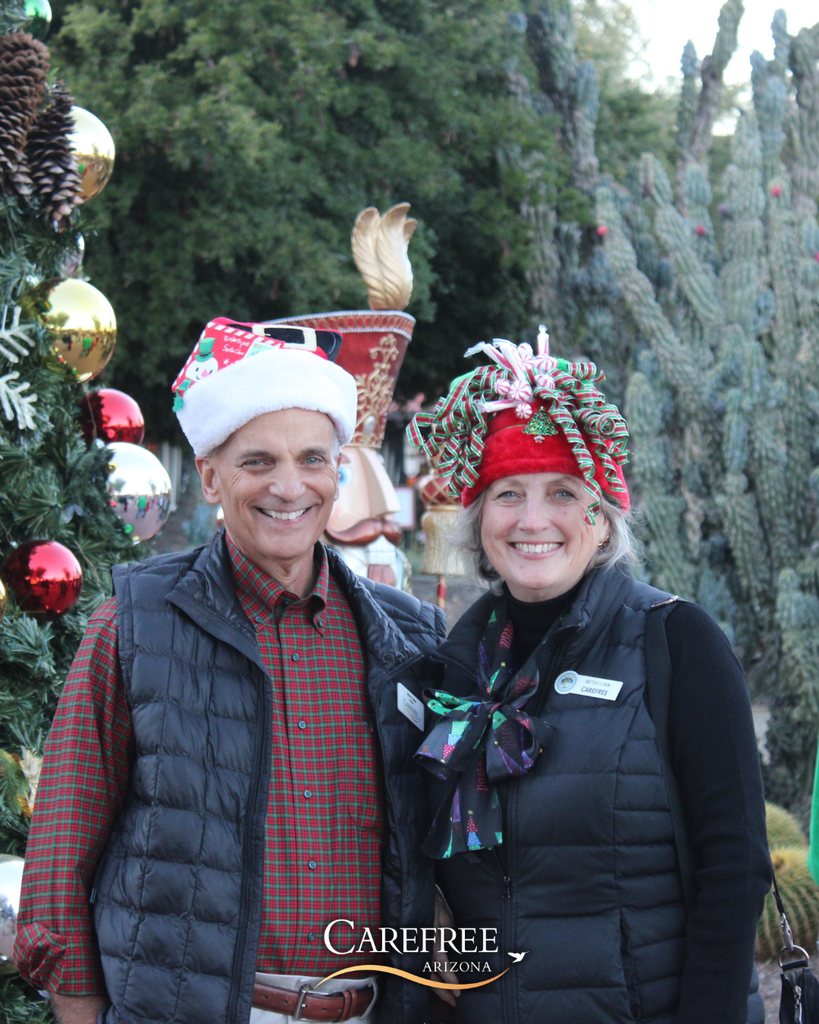 Mayor and his wife smiling at the camera in Christmas hats
