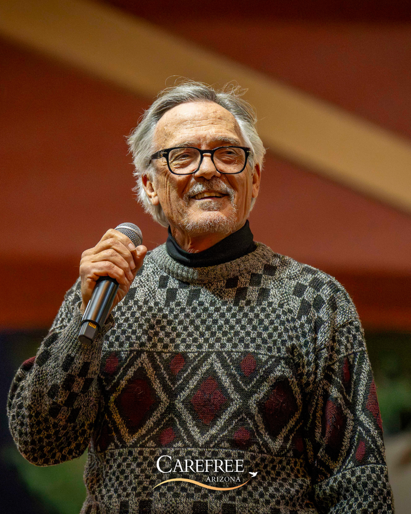 Older man singing and smiling with microphone