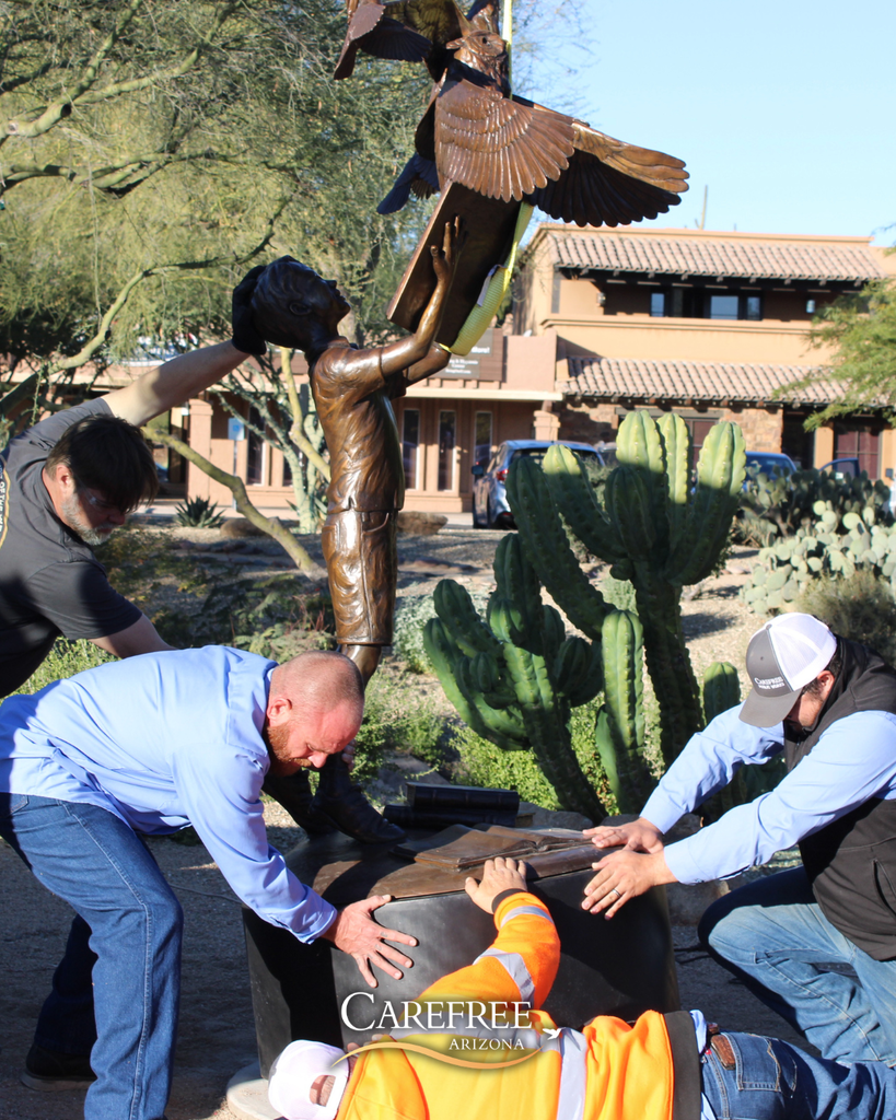 Public works team working together to install sculpture