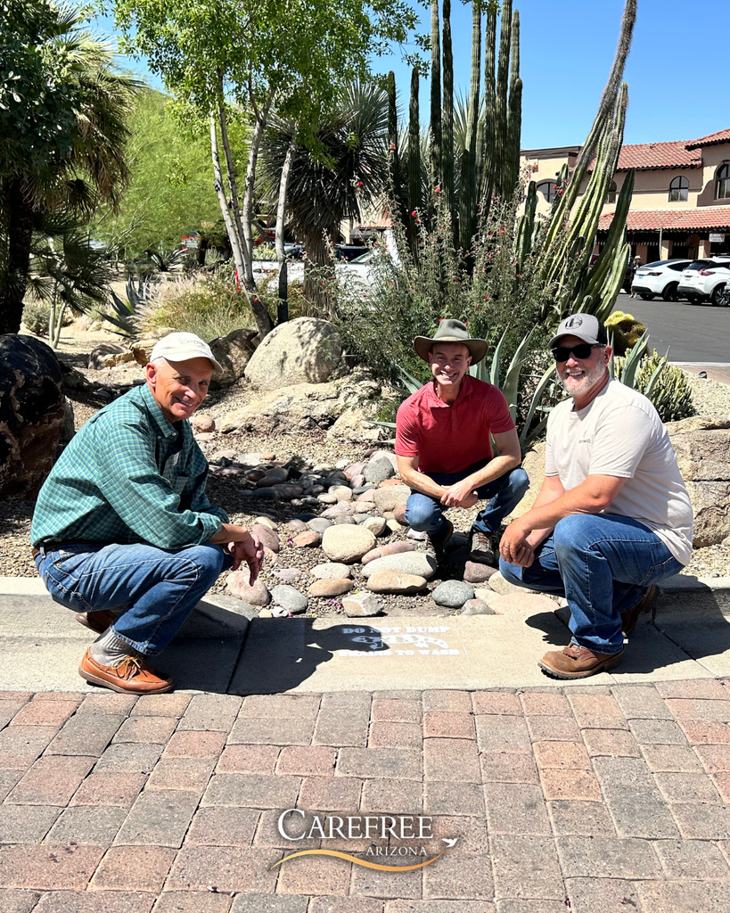 Mayor, Town Engineer and Public Works smiling in front of storm drain painting