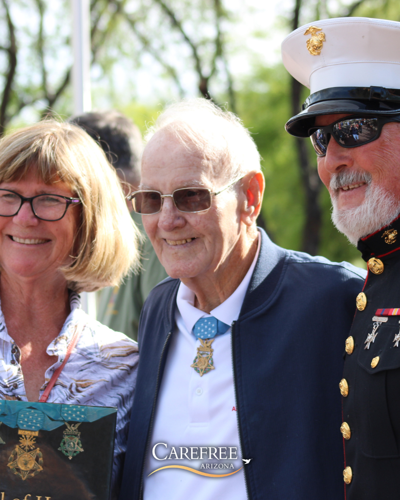 Woman and two men smiling at camera
