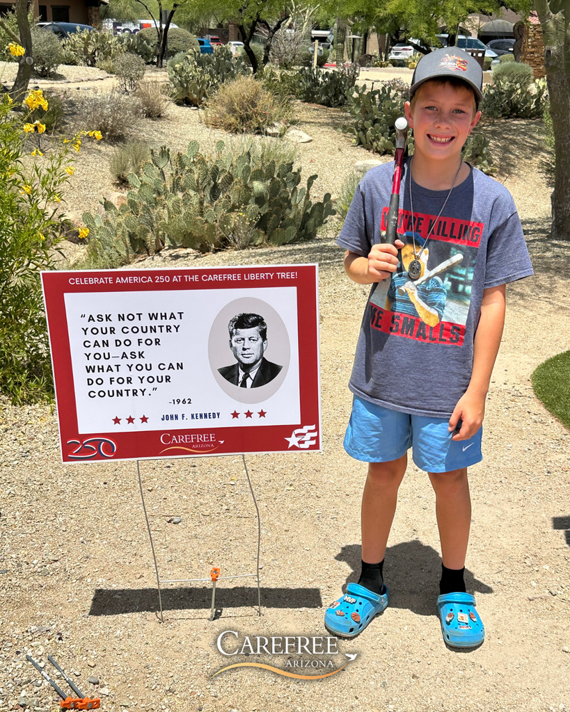 Cynthia's nephew standing next to sign he just installed