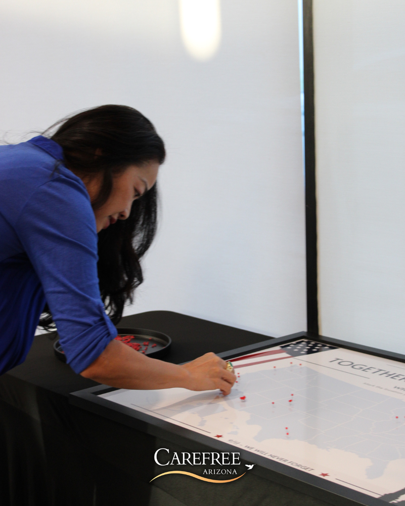 Woman placing pin into Where Were You map