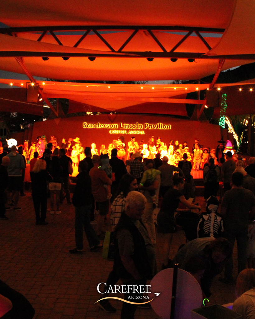 Crowd gathered at Sanderson Lincoln Pavilion in Carefree, Arizona, watching a brightly lit stage at night.