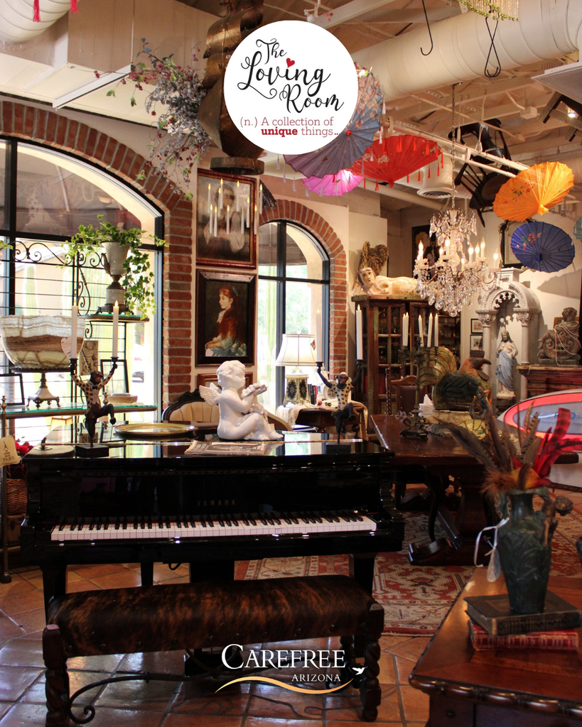 Elegant interior of The Loving Room featuring a grand piano, vintage decor, and colorful hanging umbrellas in Carefree, Arizona.