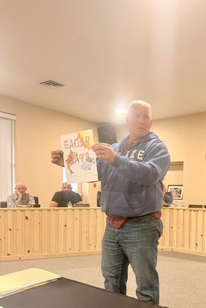 Councilman Burnham holding up logo drawing 