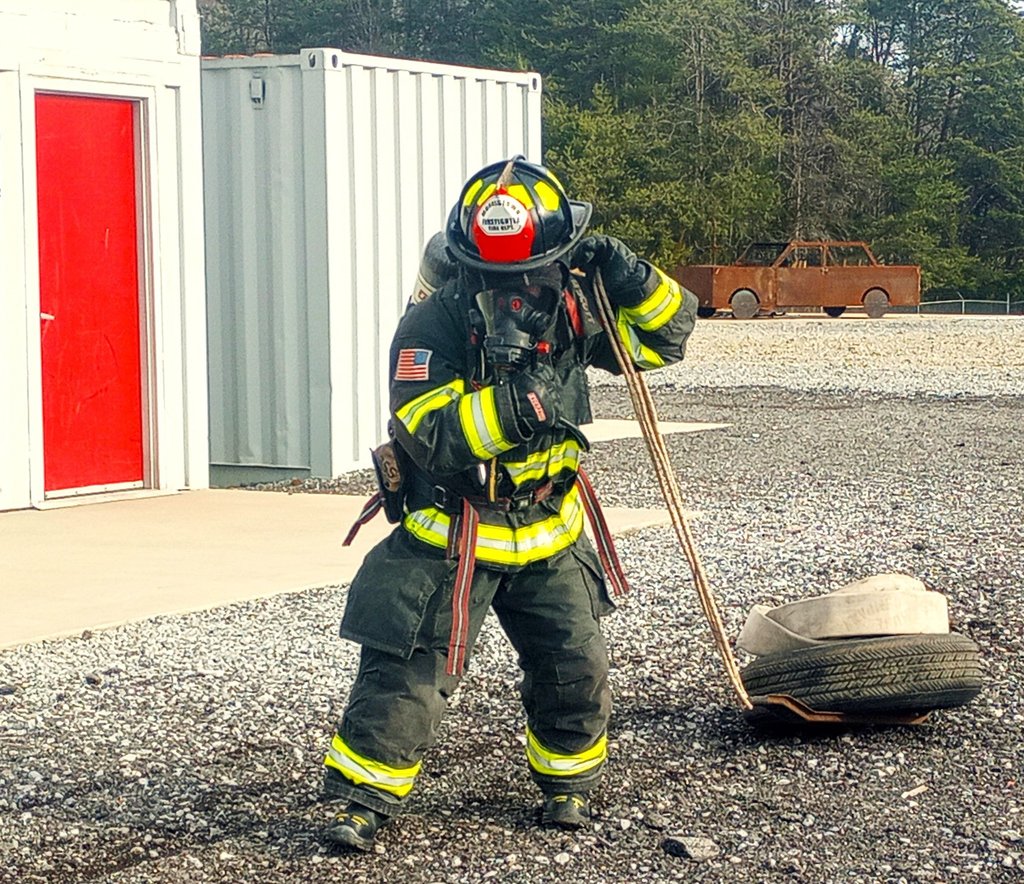 firefighter dragging weight with equipment on