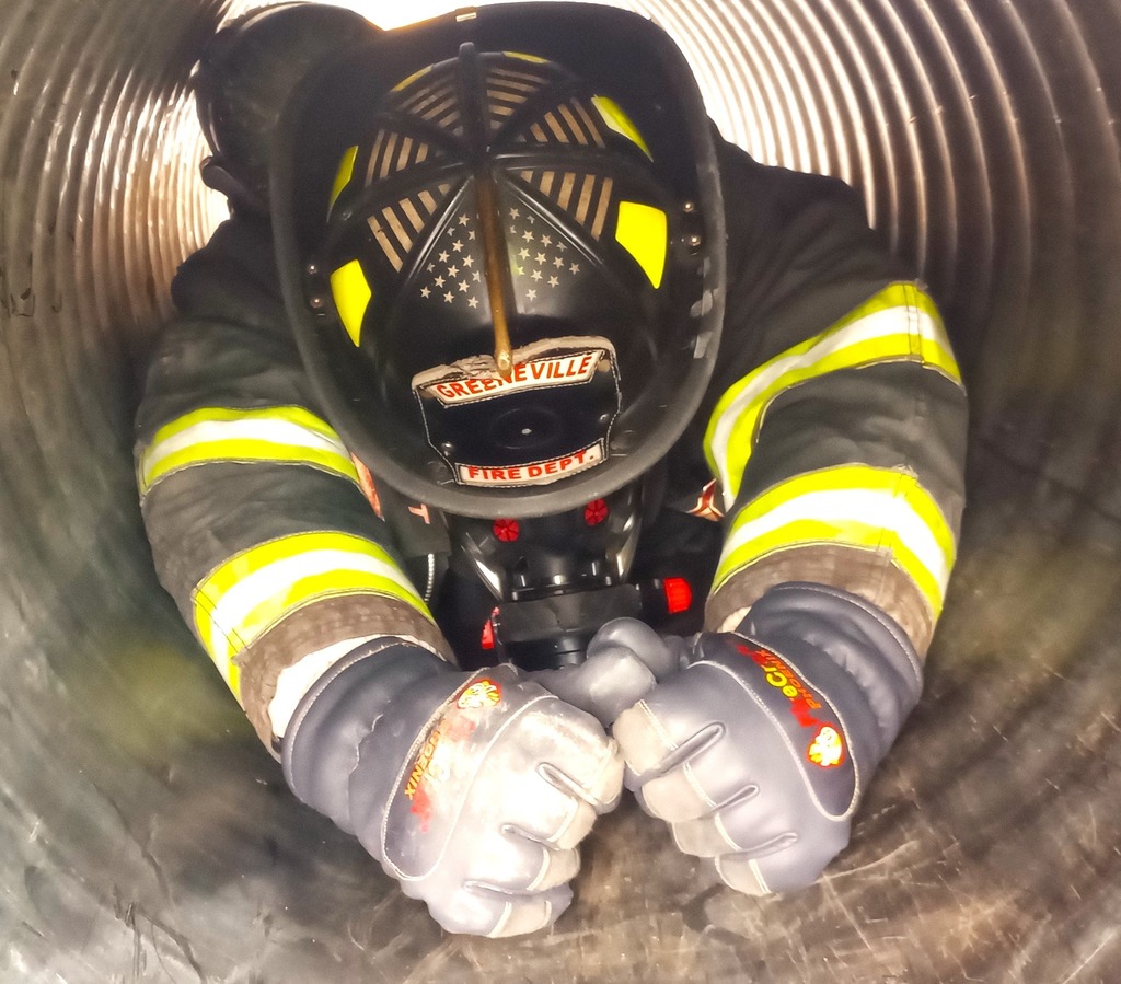 firefighter crawling through pipe