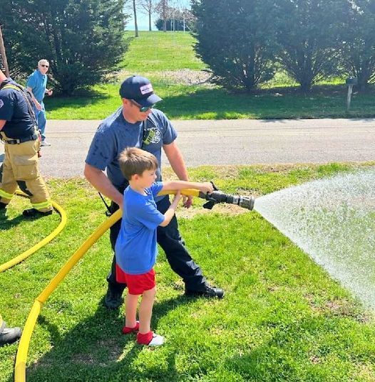 Firefighter helping a child with a fire hose
