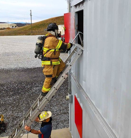 Firefighter on a ladder opening up a window simulator