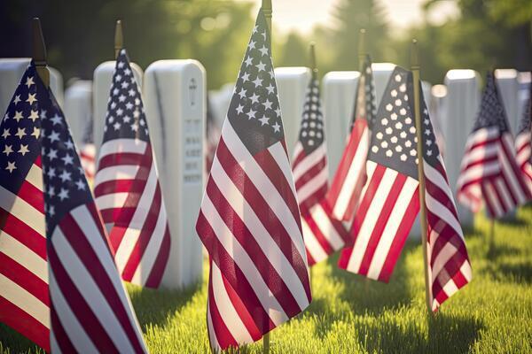 Photo of American Flags placed in front of headstones at a veterans cemetery
