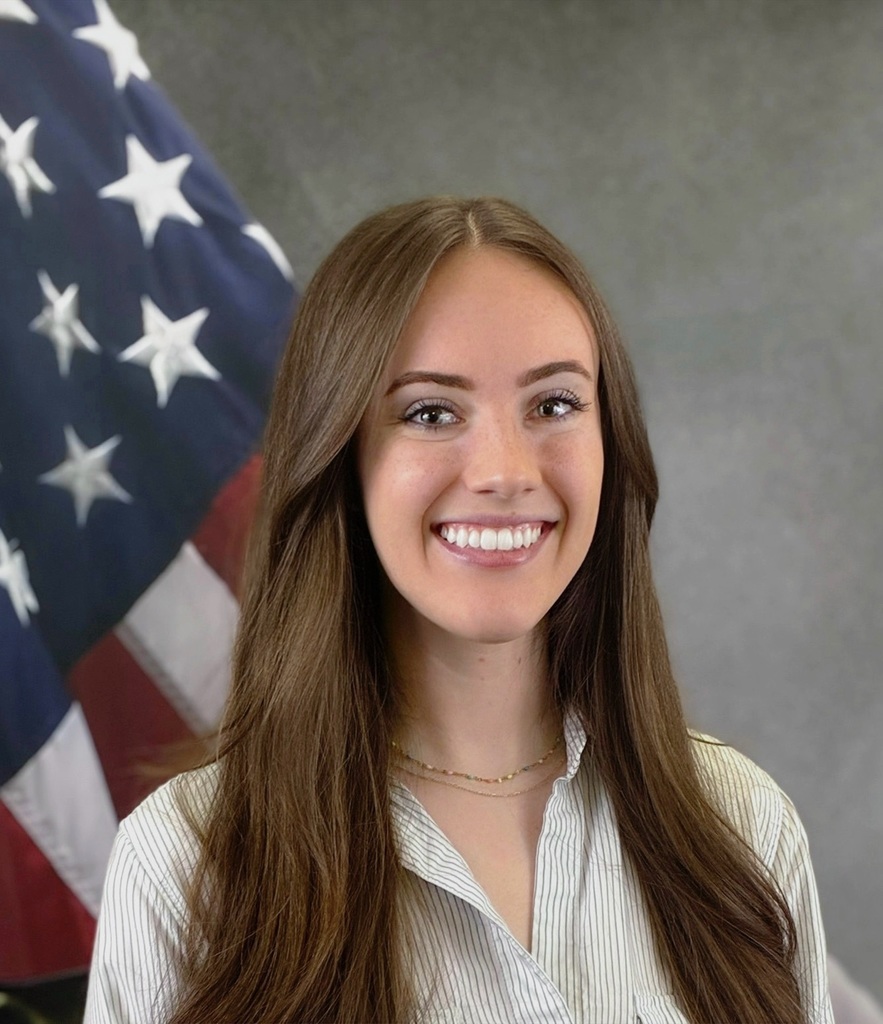 Photo of Taylor Gray with American flag in the background 