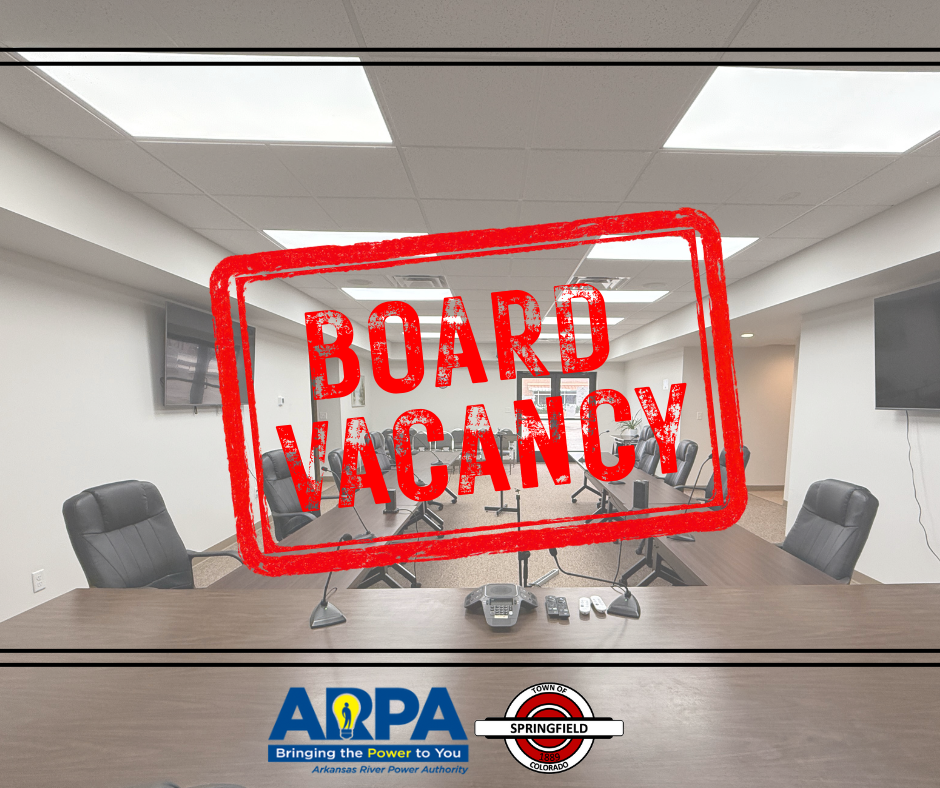 Conference room with empty chairs around a large table, overlaid with a bold red stamp graphic that reads 'BOARD VACANCY.' At the bottom are logos for ARPA (Arkansas River Power Authority) and the Town of Springfield.