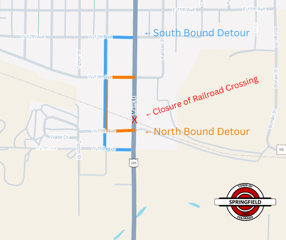 Map showing road closure at the railroad crossing on Main Street in Springfield, Colorado, marked with a red X and labeled ‘Closure of Railroad Crossing.’ Northbound detour is shown in orange along W 15th Avenue and Colorado Street, while the southbound detour is shown in blue along W 12th Avenue and Colorado Street. The Town of Springfield logo appears in the bottom right corner