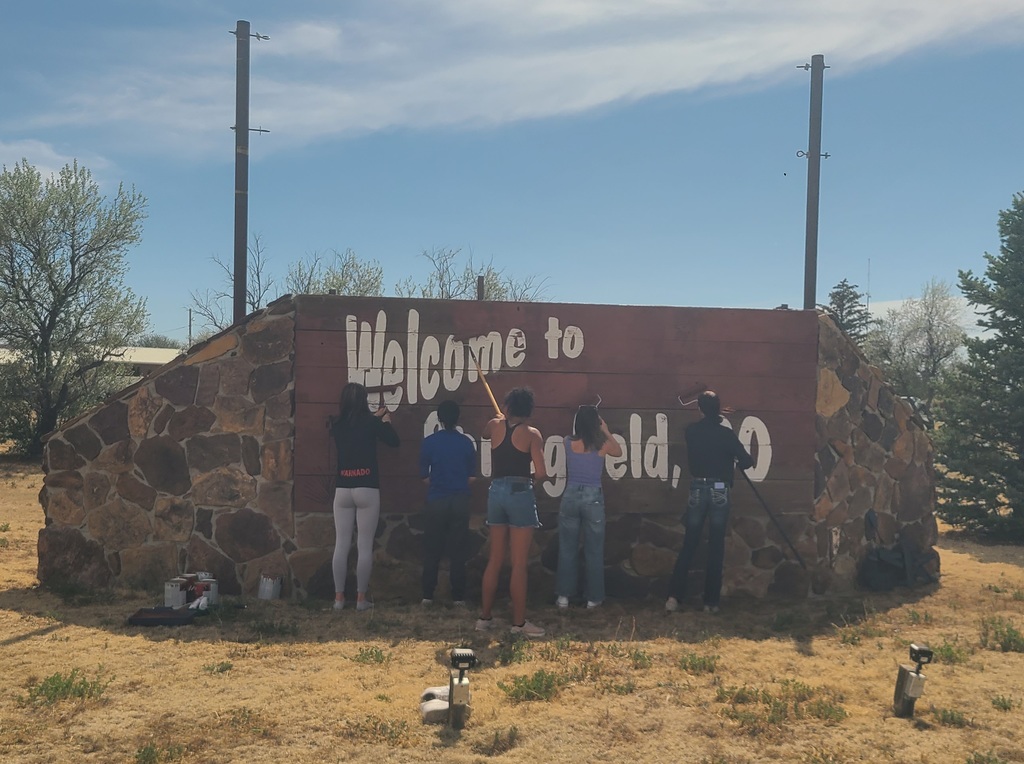 Group of high school kids painting the welcome sign for Springfield, CO!