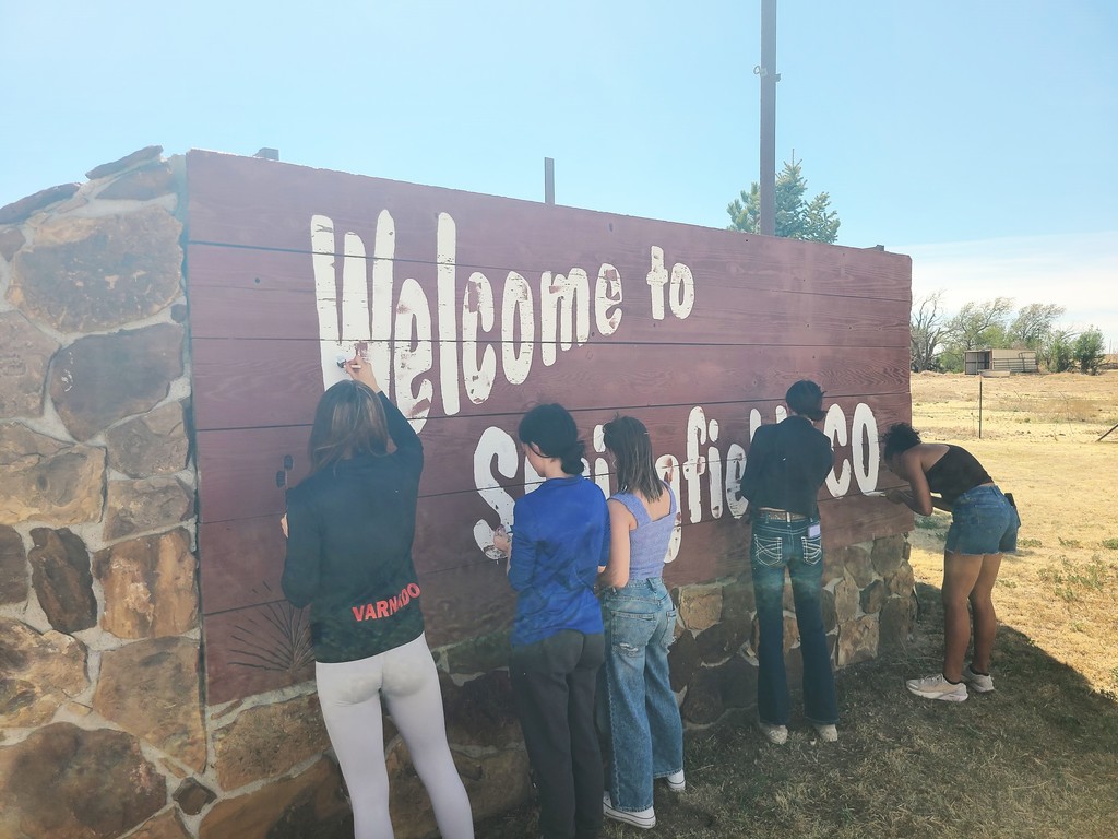 Group of high school kids painting the welcome sign for Springfield, CO!