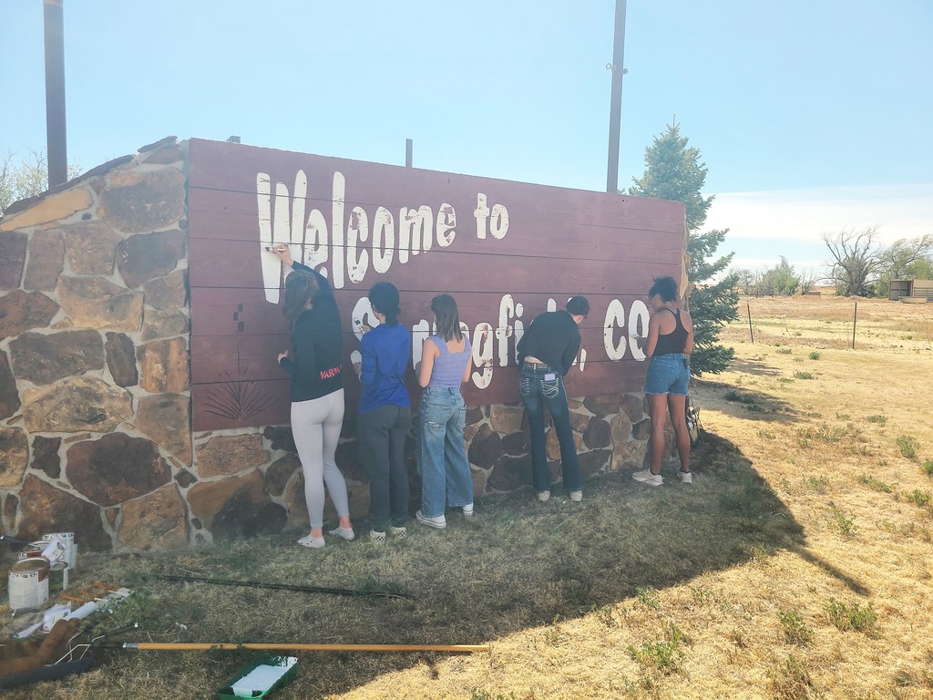 Group of high school kids painting the welcome sign for Springfield, CO!