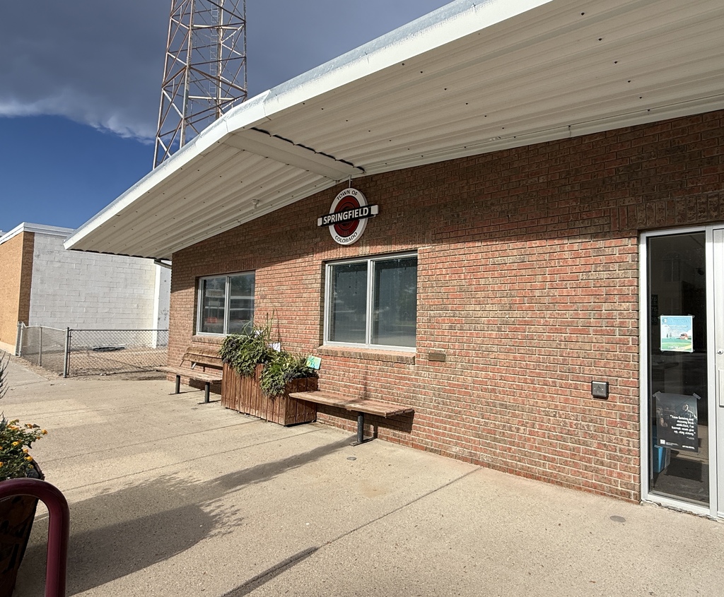Exterior of a brick building with a “Town of Springfield, Colorado” sign above the entrance.