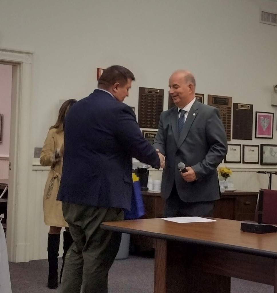 Board of Education Chairman Paul Grabowski congratulates Mayor Dan Champagne for receiving adult education award