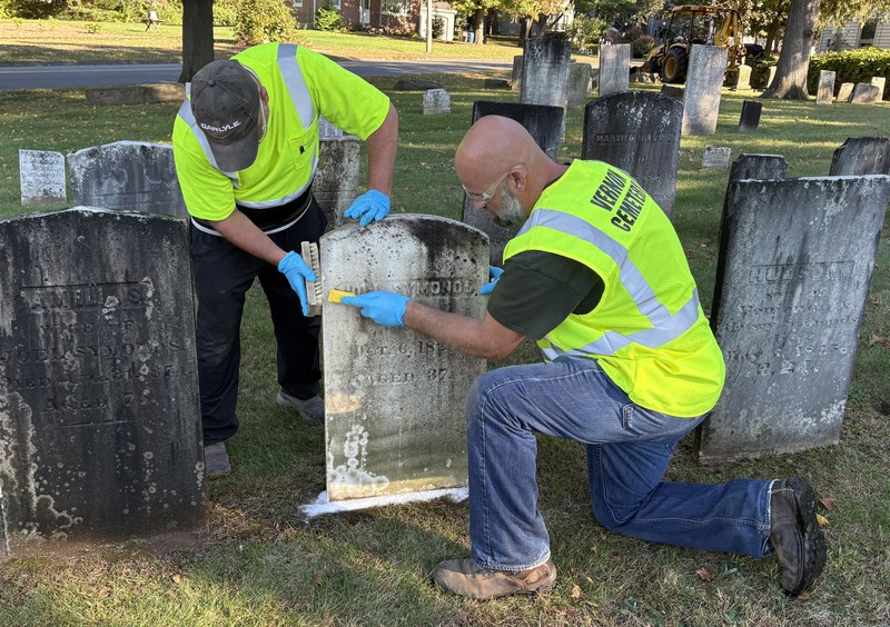 Workers cleaning a grave stone