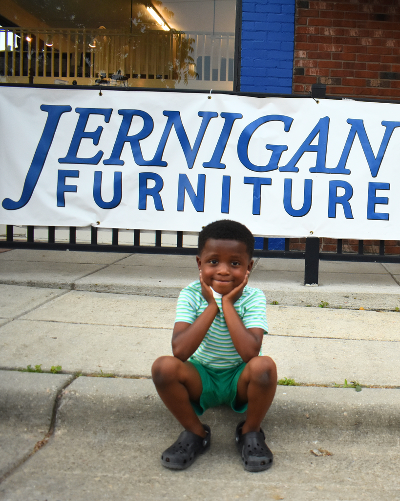 little boy in front of furniture store