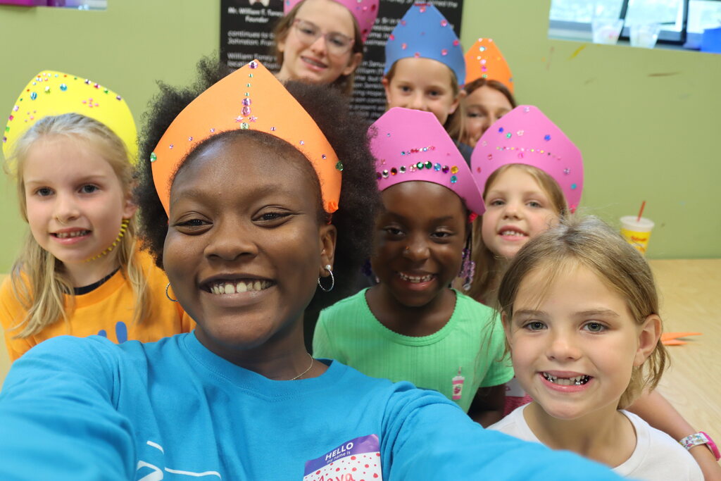 Children smiling and wearing handmade crowns at Broadway Bootcamp.