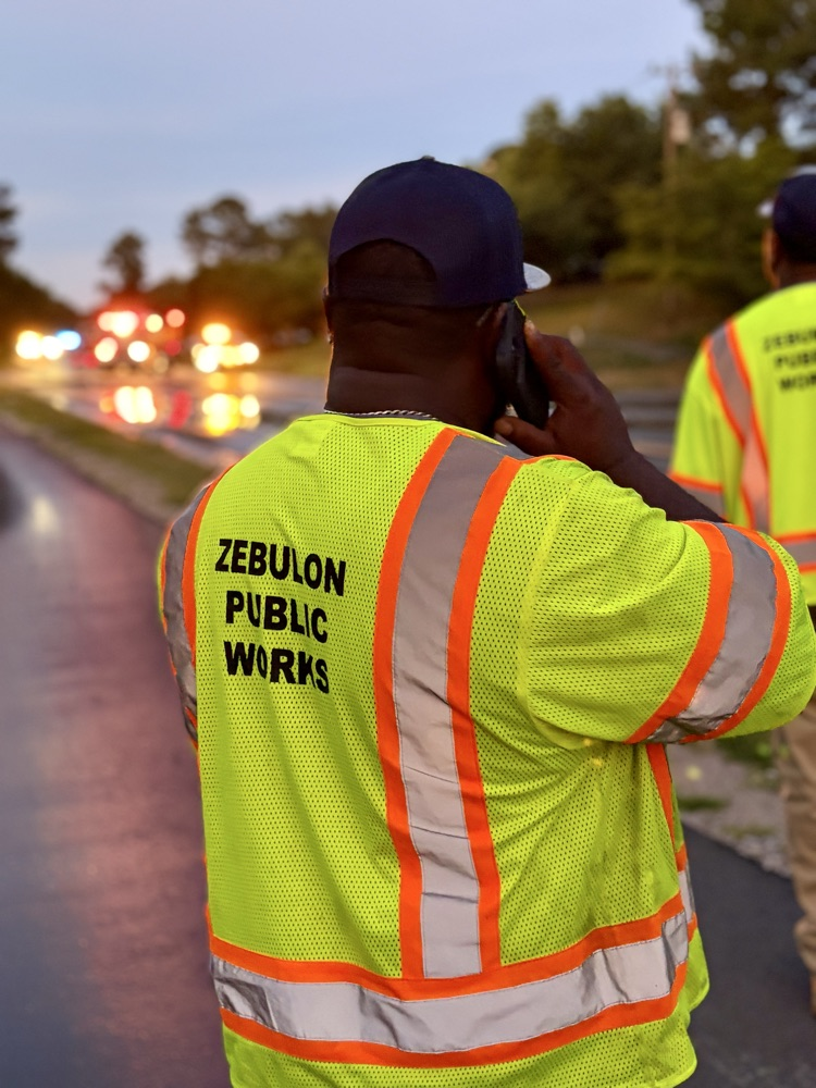 public works person standing at water