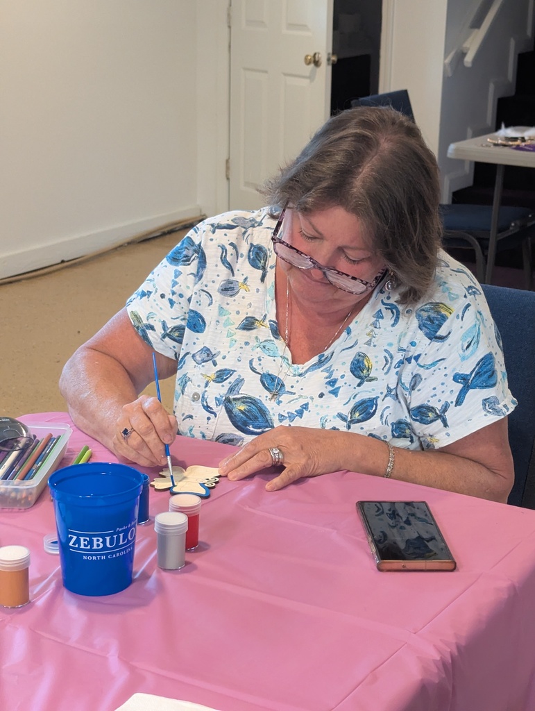 Person painting a butterfly wooden craft