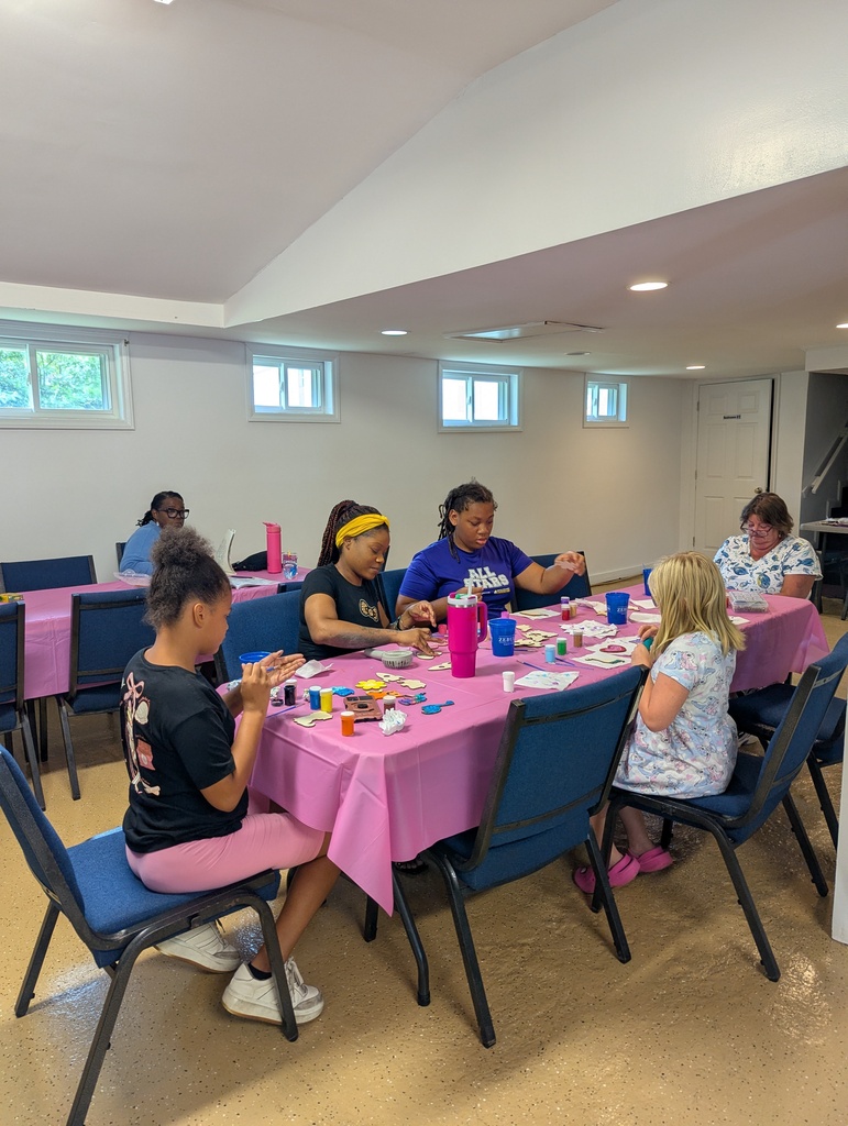 Group of people painting wooden crafts