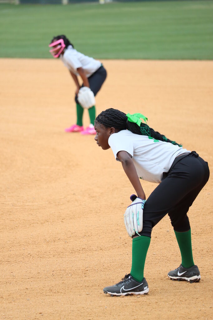 Two children playing softball