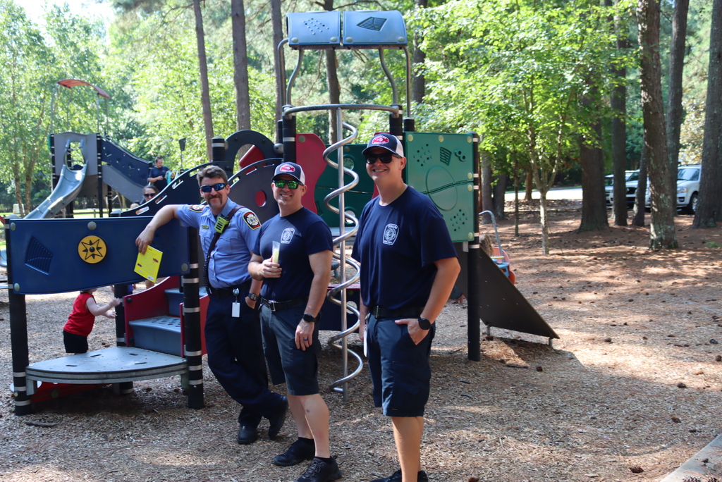 Firefighters smiling at camera while standing at the park