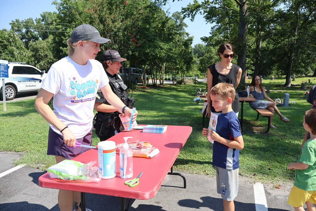 Staff serving a child a popsicle