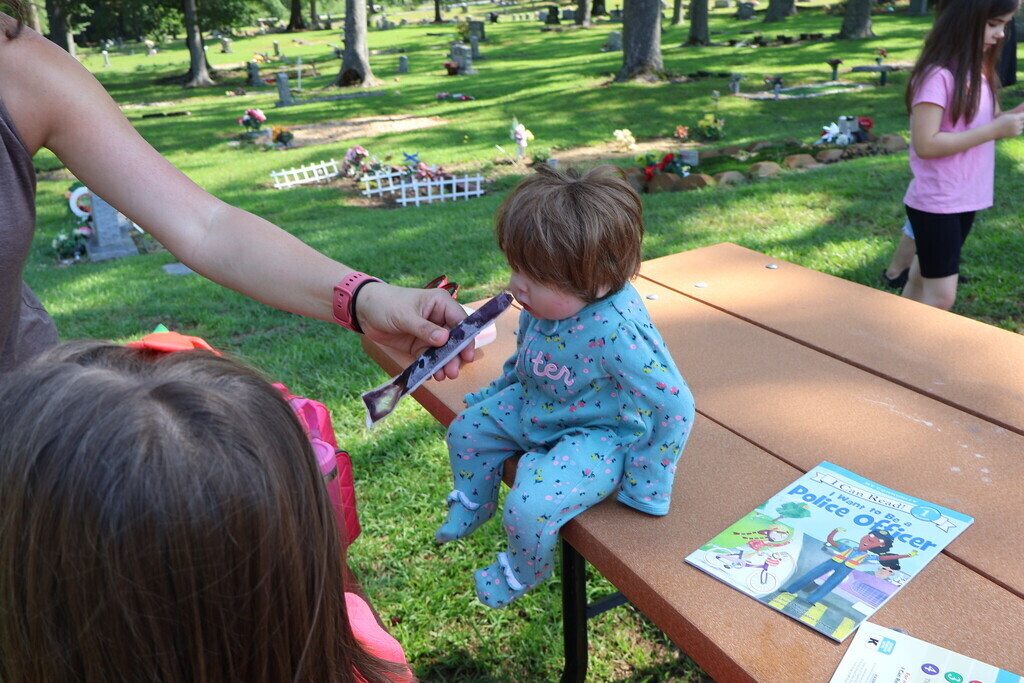Feeding a baby doll a popsicle
